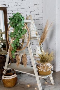 scandinavian decoration for cozy home made with dry herbs, photo frame, candles and garlands on white background