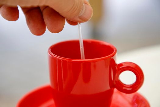 Hand manual stir in a cup of coffee or tea. Close