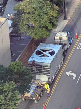 enormous cooling tower being installed on a highrise