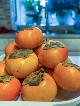fresh persimmons on a kitchen table 