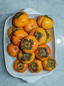 fresh persimmons on a kitchen table 