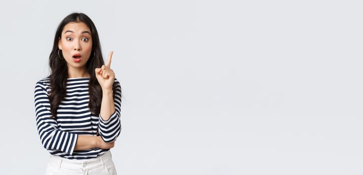 Lifestyle, people emotions and casual concept. Excited smart and creative asian female coworker have suggestion, add idea, raising index finger to say thought or plan, standing white background.