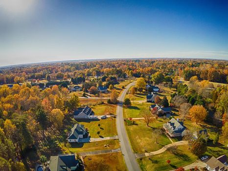 aerial view of colorful trees in a neighborhood before sunset