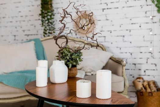 white candles on wooden coffee table in cozy living room interior