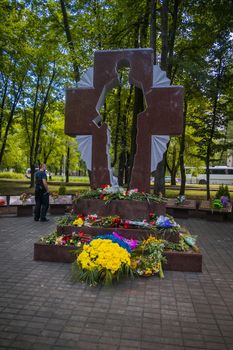 Krivoy Rog, Ukraine - may 18, 2020: A man with flowers near the memorial to fallen soldiers - defenders of Ukraine while honoring the memory of those killed in the battles for Debaltseve