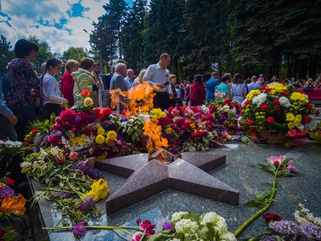 Kryvyi Rih, Ukraine - 05.09.2021 : Unidentified veterans lay flowers at Victory Monument during the celebration of Victory Day on May 9