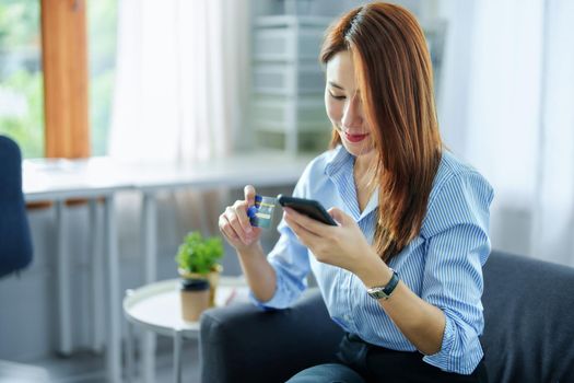 Online Shopping and Internet Payments, Portrait of Asian woman are using their credit cards and to smart mobile phones shop online or conduct errands in the digital world