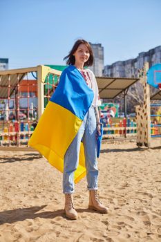 Portrait of a joyful Ukrainian woman holding a child and a Ukrainian flag. The girl is waiting for her husband from the war. War between Russia and Ukraine