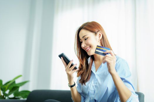 Online Shopping and Internet Payments, Portrait of Asian woman are using their mobile phones and credit cards to shop online or conduct errands in the digital world