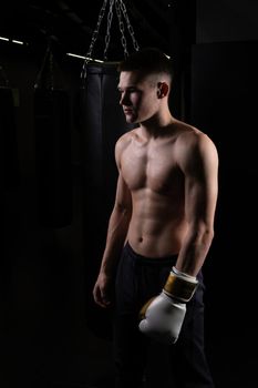 Practices boxer athlete the The blows bag glove black young background boxing, In the afternoon strong fighter from punch from fit guy, sportswear martial. Person victory dark, one