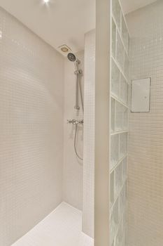 The interior of a bathroom in a cozy house with a toilet separated by a glass partition