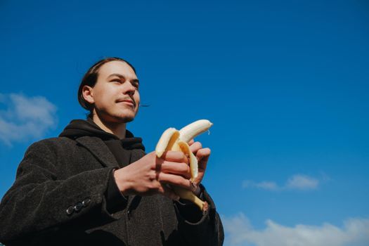 killer man with a banana instead of a gun. angry and confident look. Portrait of a nerd with mustache holding a banana weapon in his hand.