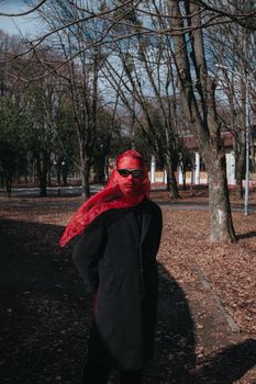 Superhero man with red mask and sunglasses fashion fighter in the park