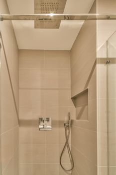 Glass shower cabin in the bathroom in beige design in a modern house