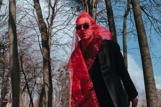 Superhero man with red mask and sunglasses fashion fighter in the park