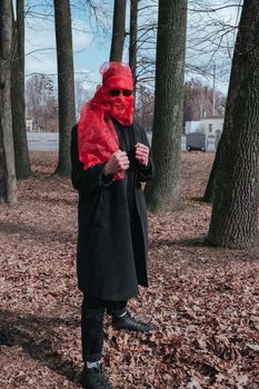 Superhero man with red mask and sunglasses fashion fighter in the park