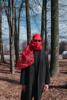 Superhero man with red mask and sunglasses fashion fighter in the park