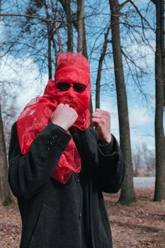 Superhero man with red mask and sunglasses fashion fighter in the park