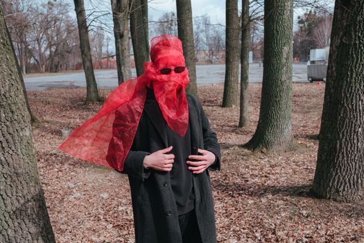 Superhero man with red mask and sunglasses fashion fighter in the park