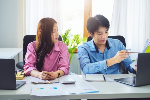 negotiation, analysis, discussion,asian male economist pointing out a document explaining the investment finance program to the company owner to plan marketing and hedging business risks