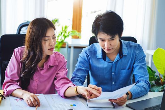 negotiation, analysis, discussion,asian male economist pointing out a document explaining the investment finance program to the company owner to plan marketing and hedging business risks