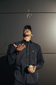 Young african american man holding peanuts on black background street