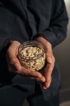 Different types of nuts, nut mix of peanuts in black hands.