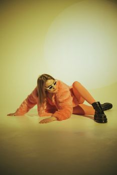 Fashion model in pink suit and sunglasses. Studio shot.