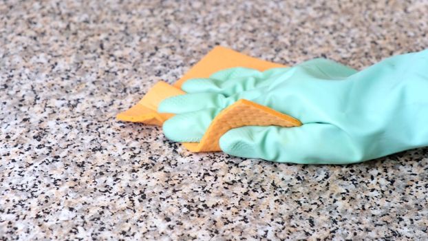 Hand Cleaning Kitchen Work Surface with Rubber Gloves and Disinfectant Spray. The concept of cleaning, help around the house.
