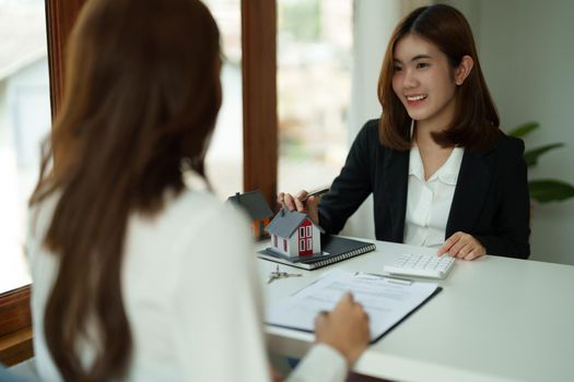 Real estate agent or bank officer describes the loan interest to the customer with home purchase contracts or on office loans and interest rates.
