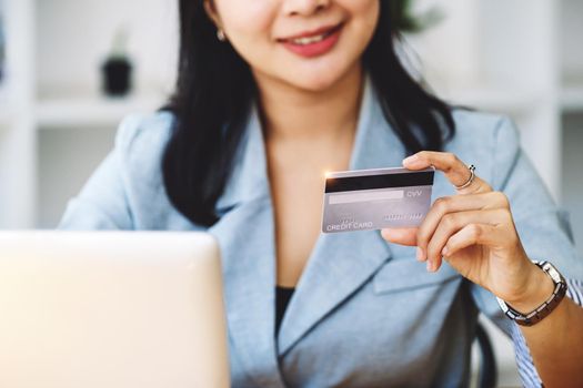 Online Shopping and Internet Payments, Asian woman are using their credit cards and laptop computer to shop online or conduct errands in the digital world