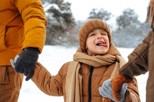 Happy family having a walk in winter outdoors in snow forest