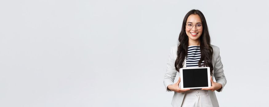 Business, finance and employment, female successful entrepreneurs concept. Friendly smiling real estate broker showing best deal to clients on digital tablet display, working with customers.