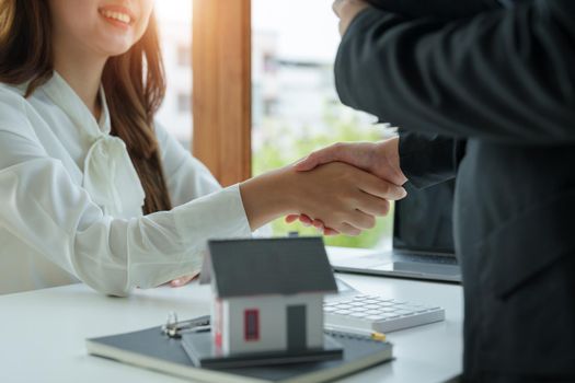 Estate agent and customer shaking hands after finished contract after about home insurance and investment loan.