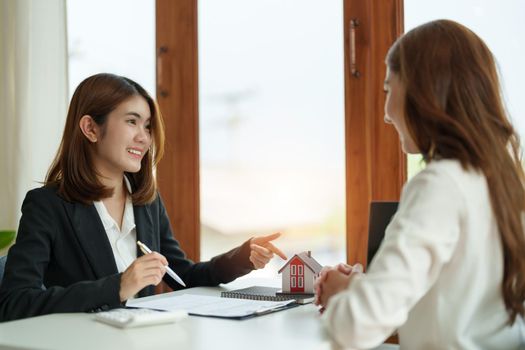 Real estate agent or bank officer describes the loan interest to the customer with home purchase contracts or on office loans and interest rates