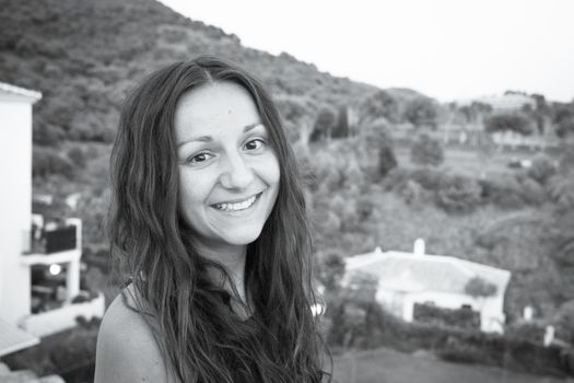 Portrait of youthful woman on mountain background. Smiling.