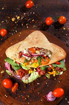 Doner kebab or pita on a wooden tray.