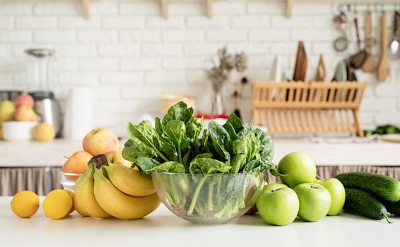 Preparing healthy foods. Healthy eating and dieting. Close up of table with green vegetables and fresh fruit in the kitchen
