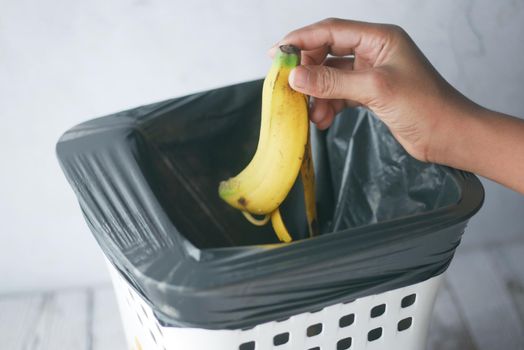 throwing banana in a garbage bin ,