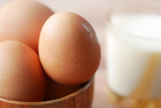 eggs in a bow and a glass of milk on table ,