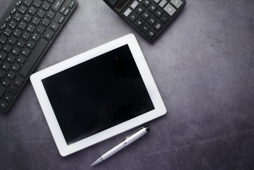 Flat composition of digital tablet and office stationary on black background .