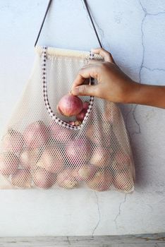 fresh onion in a reusable shopping bag ,