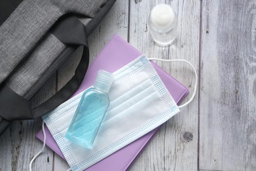 Surgical masks, and hand sanitizer on orange background .