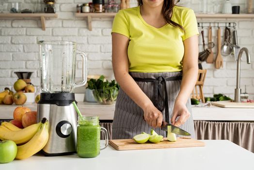 Healthy eating, dieting concept. Close up of a young woman holding a jar of green smoothie