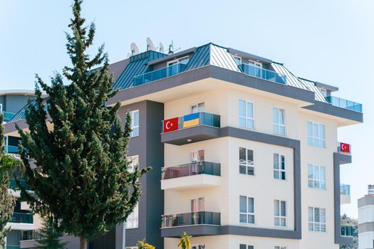 Ukraine and Turkey national flags hanging from residential building balcony. Stand with Ukraine, stop war. Ukrainian community abroad. international support concept.