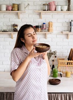 Alternative coffee brewing. young woman in lovely pajamas making coffee at home kitchen holding bowl with coffee beans