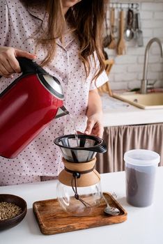 Alternative coffee brewing. young woman in lovely pajamas making coffee at home kitchen