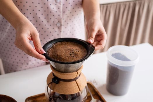 Alternative coffee brewing. young woman in lovely pajamas making coffee at home kitchen