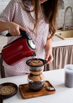 Alternative coffee brewing. young woman in lovely pajamas making coffee at home kitchen