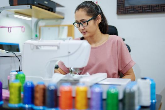 Embroidery, handicrafts, hobbies, SME business, family business, Portrait of Asian female designers are doing by designing patterns using automatic embroidery machines by customer order